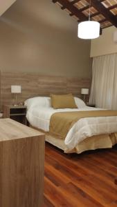 a bedroom with two beds and a wooden floor at Hotel Intersur La Cumbre in La Cumbre