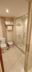 W łazience znajduje się toaleta i przeszklony prysznic. w obiekcie Hotel Intersur La Cumbre w mieście La Cumbre