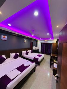 Pokój z 2 łóżkami i fioletowym sufitem w obiekcie Coorg ASHOK PALACE w mieście Madikeri