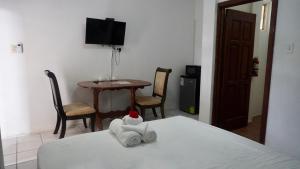 a room with a bed and a table with chairs at Old Relaxing in Belize City