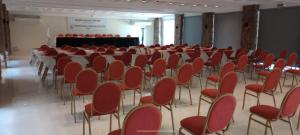 una habitación con sillas rojas y un escenario en el fondo en Hotel Intersur La Cumbre en La Cumbre