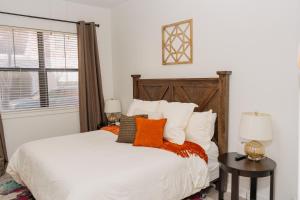 Schlafzimmer mit einem Bett mit orangefarbenen und weißen Kissen in der Unterkunft Downtown/Midtown Loft-Pool-Free Parking in Houston