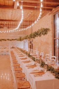 a long table with white tables and chairs in a room at Klosterhof Weingut BoudierKoeller in Stetten