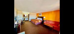 a hotel room with a bed and a couch at Scottish Inn & Suites - Eau Claire in Eau Claire