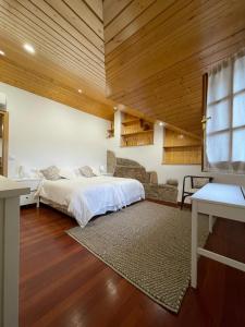 een slaapkamer met een bed in een kamer met houten plafonds bij La Casita in Nogueira de Ramuin