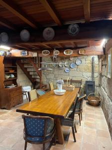 een eetkamer met een houten tafel en stoelen bij La Casita in Nogueira de Ramuin