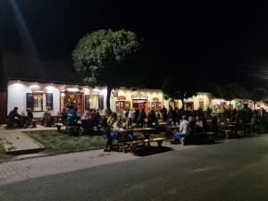 un grupo de personas sentadas en las mesas de noche en Credo Panzió, en Villány