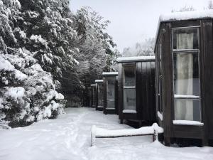 a group of huts are covered in snow at La Baita Conguillio in Conguillio