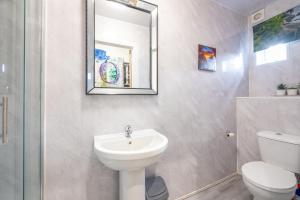 a bathroom with a sink and a toilet and a mirror at *RC246*For your relaxed & Cosy stay + Free Parking in Leeds