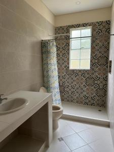 uma casa de banho com um WC, um lavatório e uma janela em Verde del Limonar Casa de Campo em Girardot