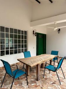 uma mesa de madeira com cadeiras e uma porta verde em Verde del Limonar Casa de Campo em Girardot