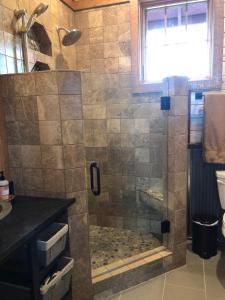 a bathroom with a shower with a glass door at New Cabin with Spectacular Views of Flathead Lake. in Somers