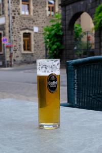 un bicchiere di birra seduto su un tavolo di Hotel Burgklause a Nickenich
