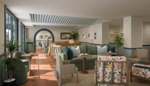 un vestíbulo con un sofá verde y sillas en Hotel Granada en Atlanta