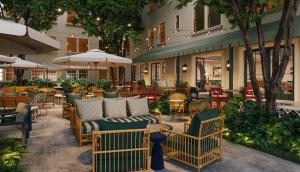 uma área de estar ao ar livre com cadeiras, mesas e guarda-sóis em Hotel Granada em Atlanta