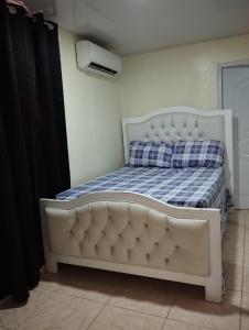 uma cama num quarto com uma cama branca em El anexos em Santiago de los Caballeros