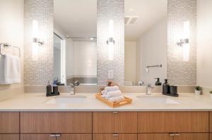 un bagno con due lavandini e un grande specchio di Family Size Luxury Residence near BC Place Stadium a Vancouver