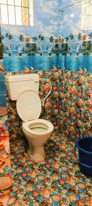 a bathroom with a toilet in a mosaic floor at Hotel Lake View Baga in Arpora