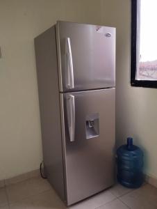 a stainless steel refrigerator in a kitchen with a window at El anexos in Santiago de los Caballeros