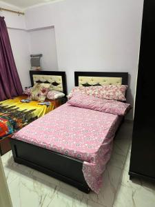 um quarto com 2 camas individuais e capas cor-de-rosa em Lily house em Alexandria