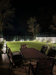 uma mesa e cadeiras num campo de futebol à noite em Oaza Mira Laze - Luxury Private Villa with Pool, Football Field em Nova Gradiska