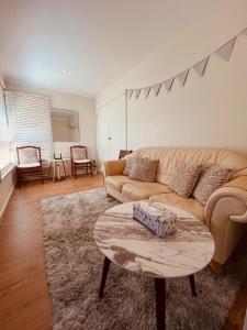 a living room with a couch and a coffee table at Cosy 3 bedroom family home near beach and shops in Frankston