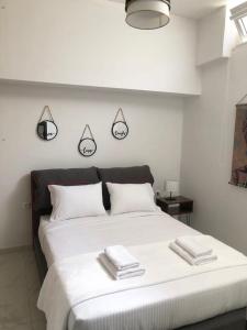 a bedroom with a large white bed with towels on it at Chrysa- Kyra Apartments in Heraklio Town