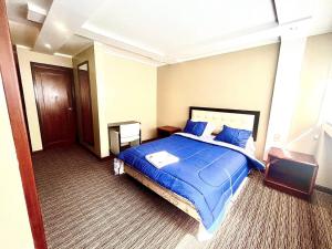 Un dormitorio con una gran cama azul con almohadas azules en 1420 Lujosa Habitación - Hotel Akros, en Quito