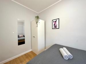 a bedroom with a bed with two white towels on it at MMRent Bubble Gum Room in Gdańsk