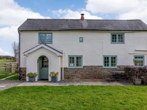 una gran casa blanca con una puerta verde en 2 Bed in Ashreigney 75412 en Ashreigney