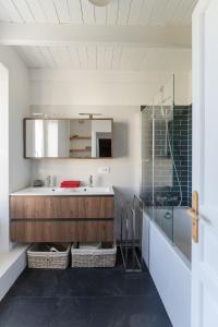 ein Bad mit einem Waschbecken und einem Spiegel in der Unterkunft TY STREJOU - Jolie maison de pêcheur proche port in Ploudalmézeau
