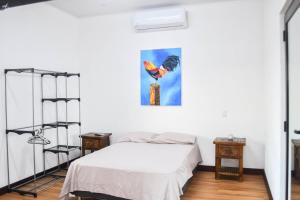 een slaapkamer met een bed en een schilderij aan de muur bij La casa Blanca Ticuantepe in Ticuantepe