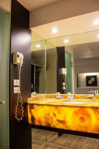 a bathroom with a large mirror and a sink at Hotel Harare in Mexico City