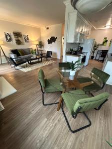 a living room with a glass table and green chairs at Beverly Hills Midle City 1 br Apt with Parking 202 in Los Angeles