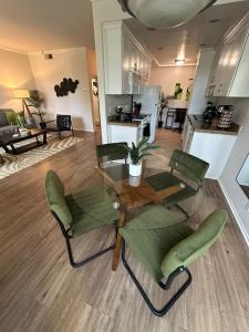 ein Wohnzimmer mit einem Tisch und grünen Stühlen in der Unterkunft Beverly Hills Midle City 1 br Apt with Parking 202 in Los Angeles
