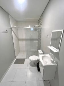 a white bathroom with a toilet and a sink at Hotel Manaus - Dom Pedro in Manaus