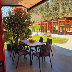 a wooden table and chairs on a patio at A Pontiga I Casa Rural in Mezonzo