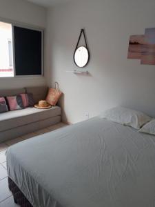 Habitación blanca con cama y sofá en Encanto Guarapari, en Guarapari