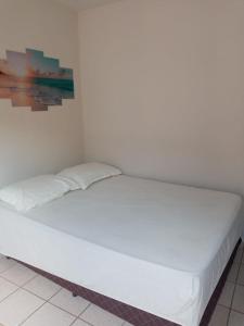 a large white bed in a white room at Encanto Guarapari in Guarapari