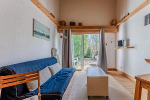 レージュ・キャップ・フェレにあるAppartement Cap Ferret Océan Réf 11のリビングルーム(青いソファ、ガラスの引き戸付)