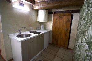 una piccola cucina con lavandino e porta in legno di Super Nice Studio Flat a Napoli Altre 35 foto