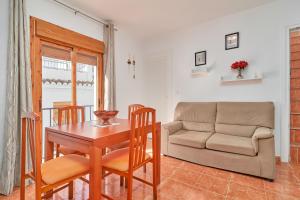 ein Wohnzimmer mit einem Tisch und einem Sofa in der Unterkunft Casa Ian in Frigiliana