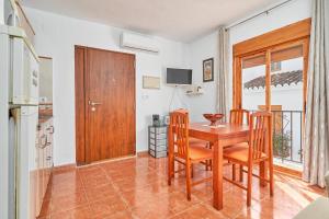 a kitchen and dining room with a wooden table and chairs at Casa Ian in Frigiliana