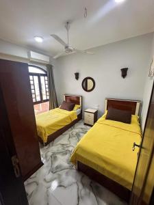 two beds in a room with yellow sheets at Elwazan Hotel in Quseir
