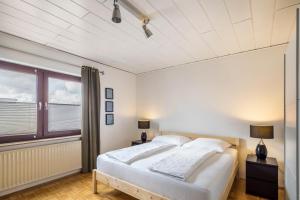 ein Schlafzimmer mit einem großen weißen Bett und einem Fenster in der Unterkunft Haus am Twistesee in Wetterburg