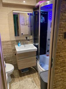 a bathroom with a sink and a toilet and a shower at Apartament morski in Gdynia