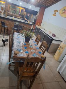 a table in a restaurant with a dog standing around it at Pousada Hotel Araguaia in Aragarças