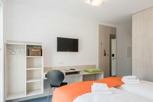 1 Schlafzimmer mit 2 Betten und einem TV an der Wand in der Unterkunft FairSleep Motel Einstein Erding in Erding