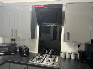 a kitchen with a stove and a microwave at Becky's Lodge - Strictly Single Adult Room Stays - No Double Adult Stays Allowed in Solihull