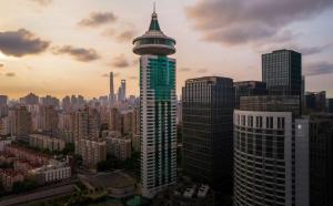 een hoog gebouw met een koepel bovenop in een stad bij DoubleTree by Hilton Shanghai Pudong - Present welcome cookie in Shanghai